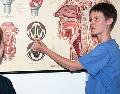 Logopädin erklärt Stimmfunktion anhand anatomischer Bilder des Kehlkopfs