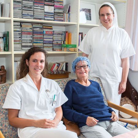 Patientin mit Pflegekräften auf der Palliativstation