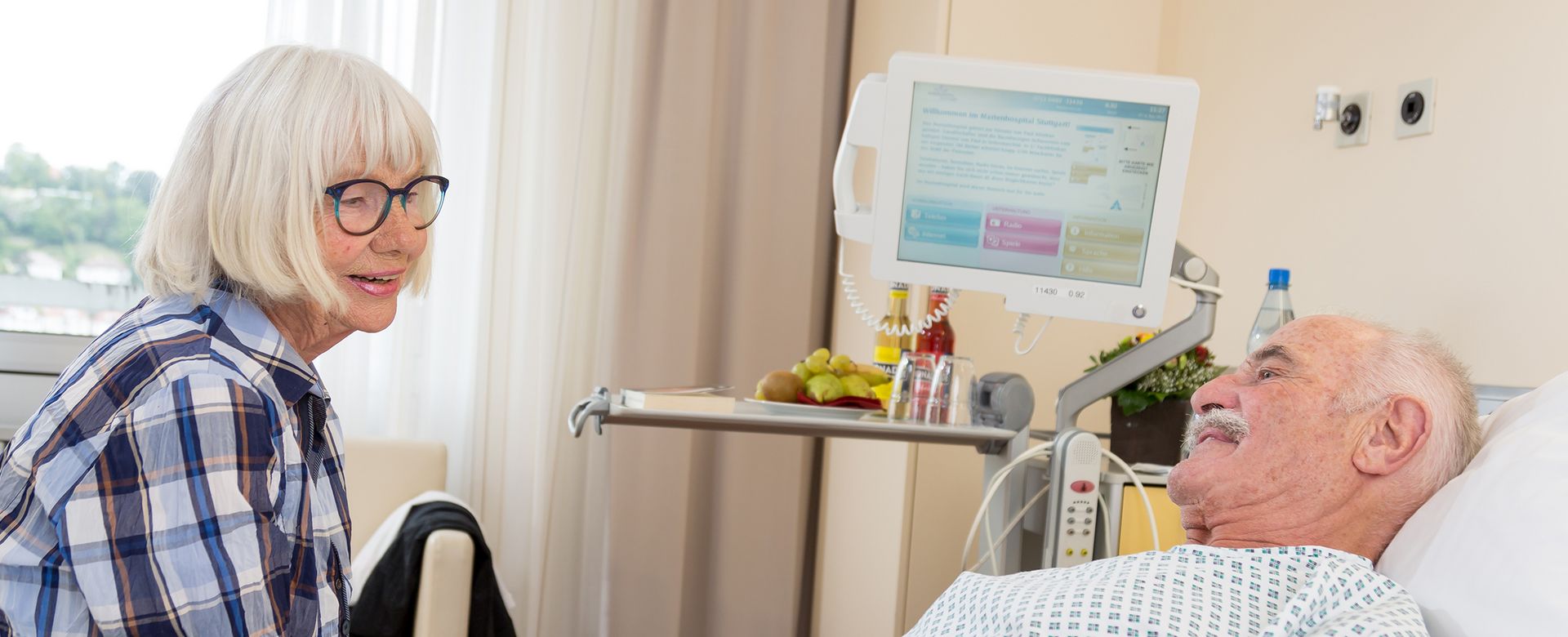 Frau besucht Patienten im Zimmer