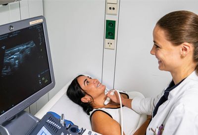Schilddrüsen-Sonografie: Der Schallkopf des Untraschallgeräts wird mit etwas Gel über den Hals der Patientin bewegt Schilddrüsen-Sonografie: Der Schallkopf des Untraschallgeräts wird mit etwas Gel über den Hals der Patientin bewegt