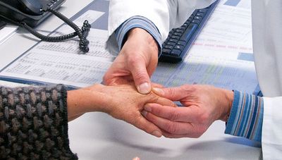 Untersuchung der Hand einer Rheumapatientin Untersuchung der Hand einer Rheumapatientin