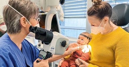 Dr. Dorothee Rickert (links) untersucht die kleine Ellie, deren Hörgerät an einem Stirnband befestigt ist