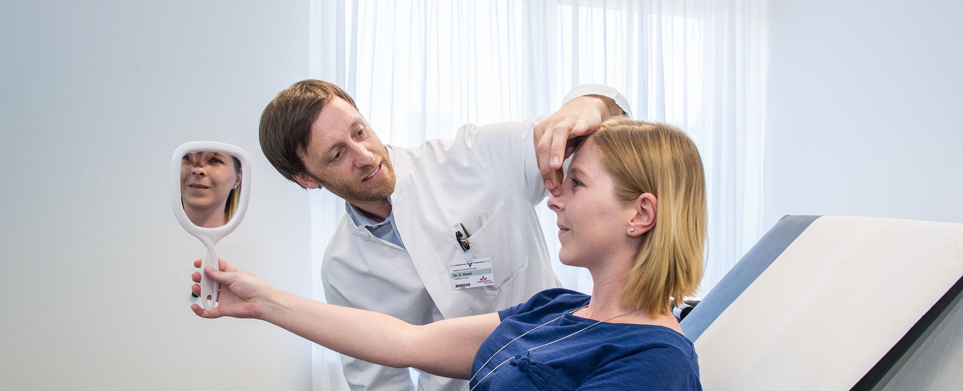 Plastischer Chirurg und Patientin mit Spiegel