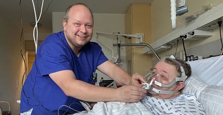 Atmungstherapeut Heiko Stopper  kontrolliert die Beatmungsmaske einer Patientin