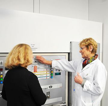 Eine Lotsin erklärt einer Besucherin den Geldwechselautomat