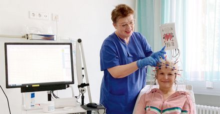 Die leitende MTA der Neurologie bereitet die Messung der Hirnstr&ouml;me mit dem EEG vor