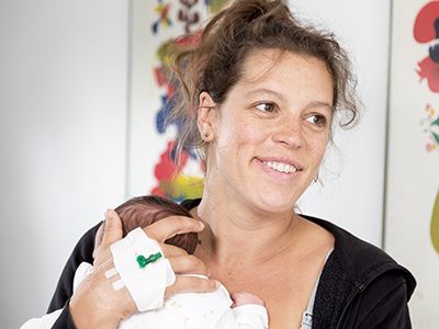 Mutter mit Neugeborenem auf dem Arm