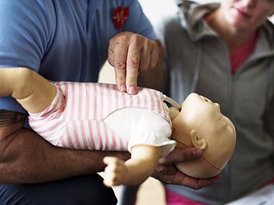 Erste Hilfe am Kinder wird an einer Puppe demonstriert