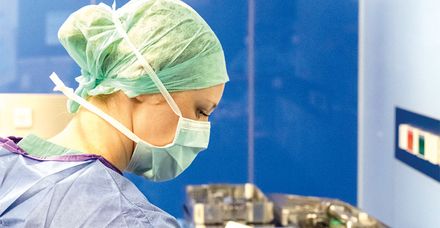 Eine operationstechnische Assistentin bereitet den sterilen Instrumententisch für eine Operation vor Eine operationstechnische Assistentin bereitet den sterilen Instrumententisch für eine Operation vor